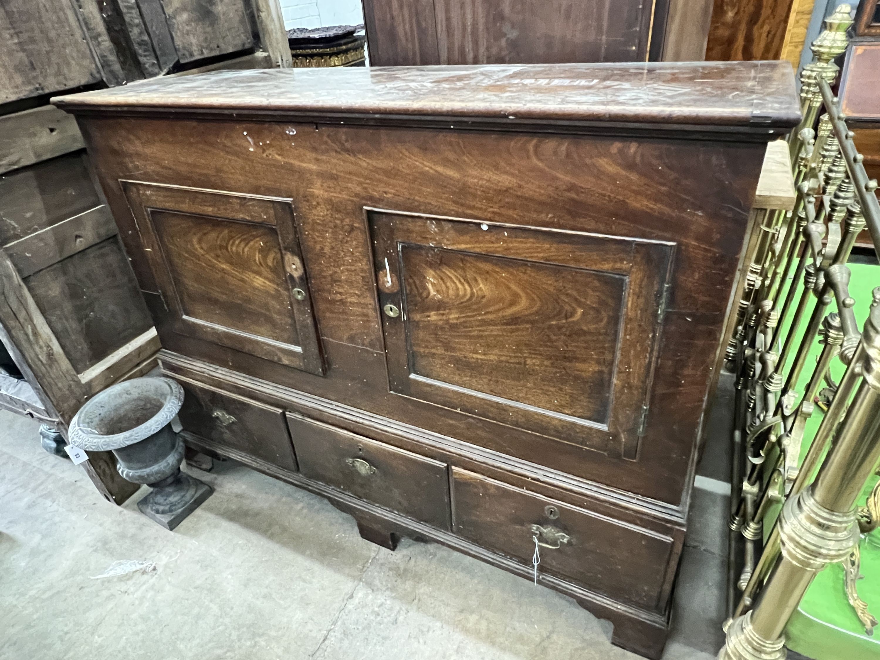 A mid 18th century fruitwood mule chest, adapted, with two panelled doors over three drawers, width 156cm, depth 57cm, height 124cm